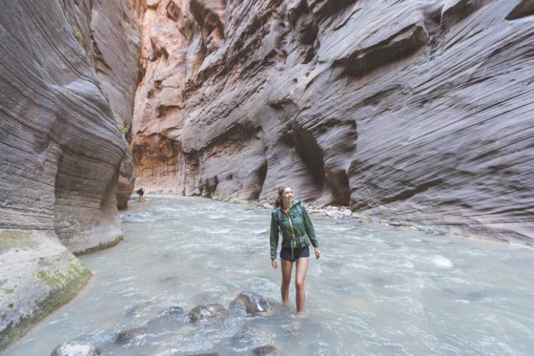 A woman hiking in a slot canyon